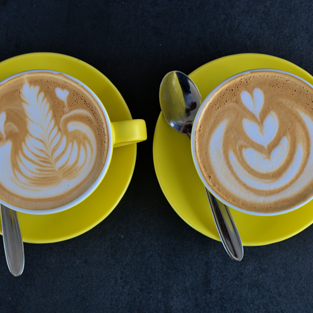 Две большие чашки капучино с рисунками на пене