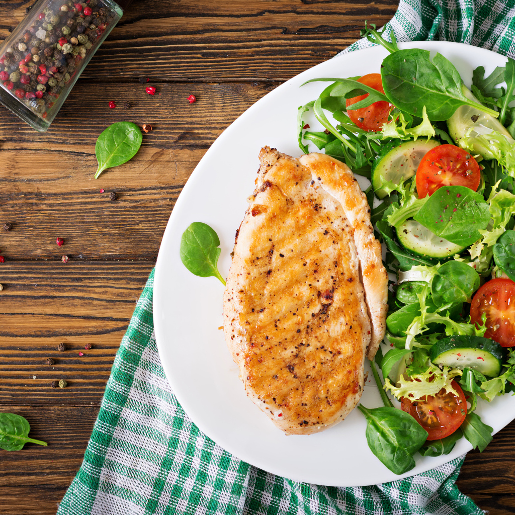 Жареная куриная грудка на тарелке с салатом