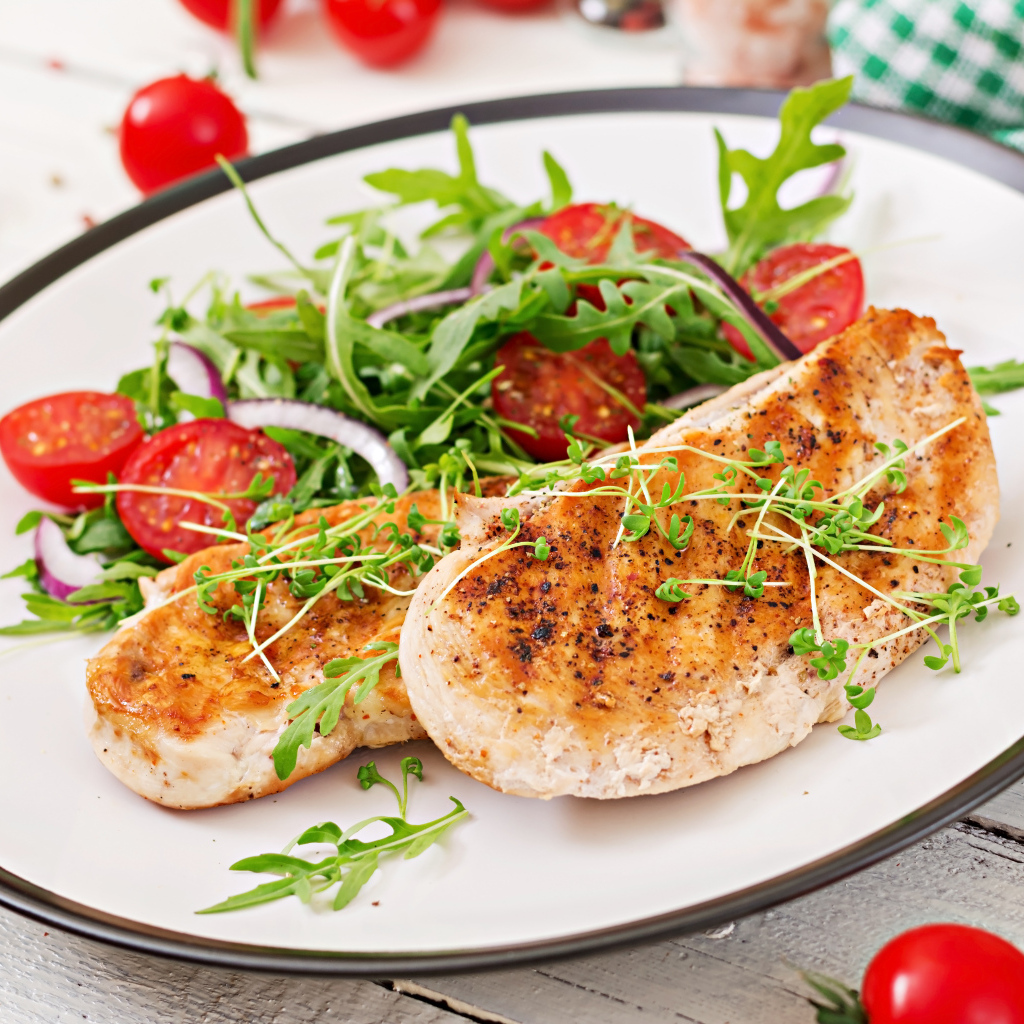 Жареная курица на тарелке с салатом