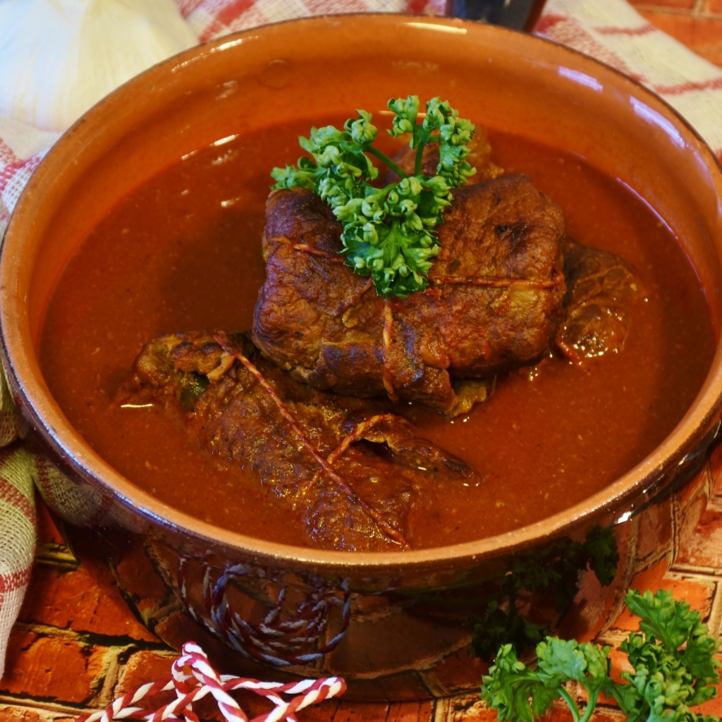 Мясные рулетики в тарелке с соусом