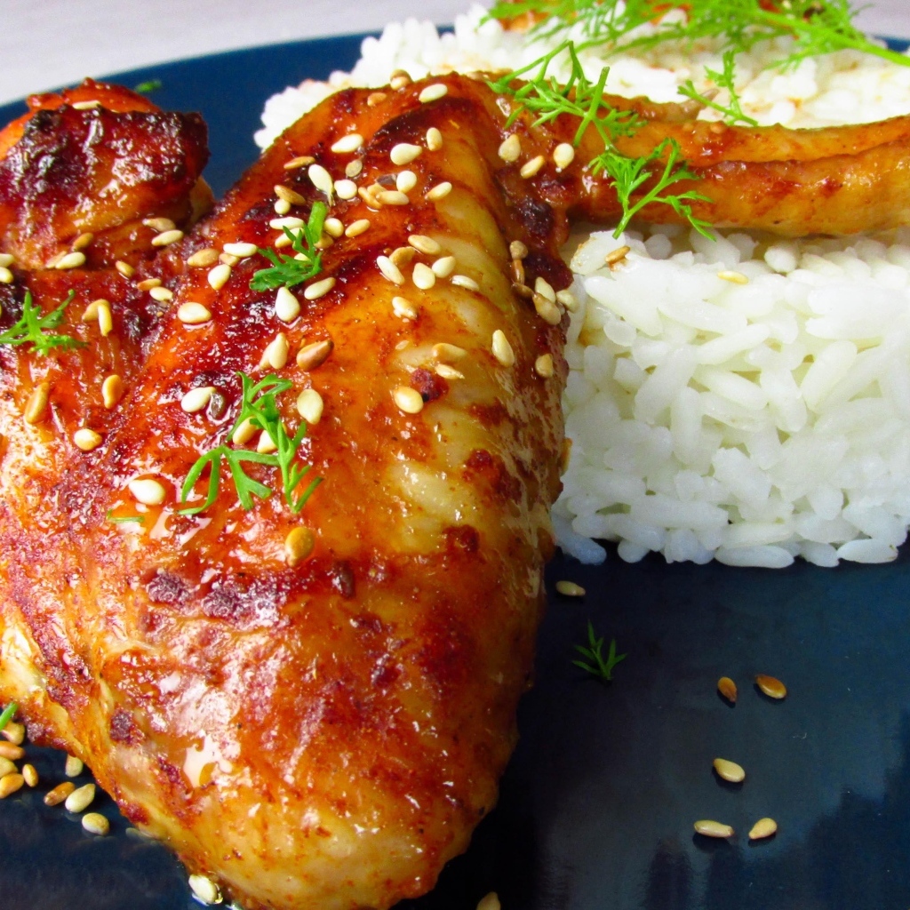 Рис на тарелке с жареным куриным крылом