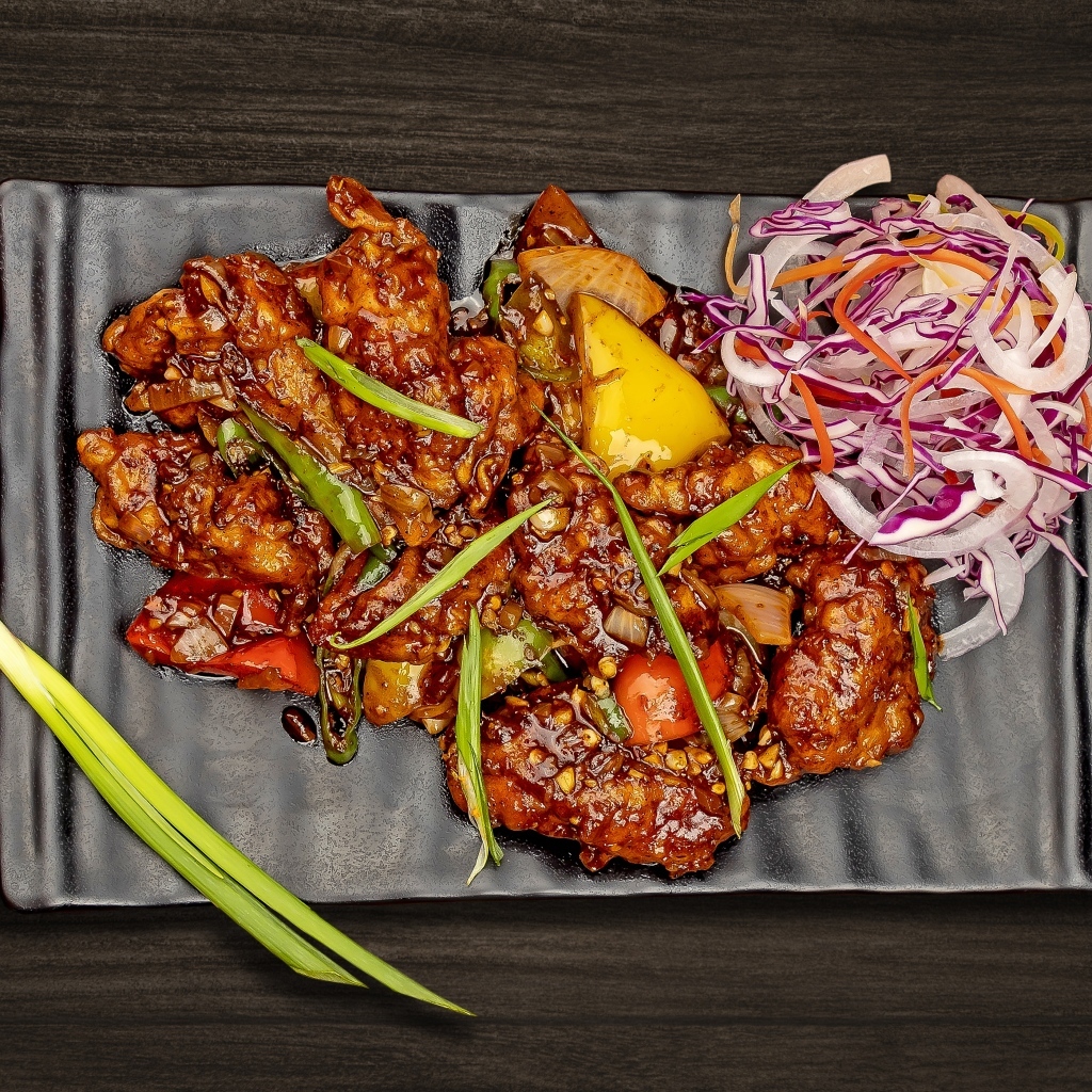 Острые куриные крылышки с салатом на тарелке