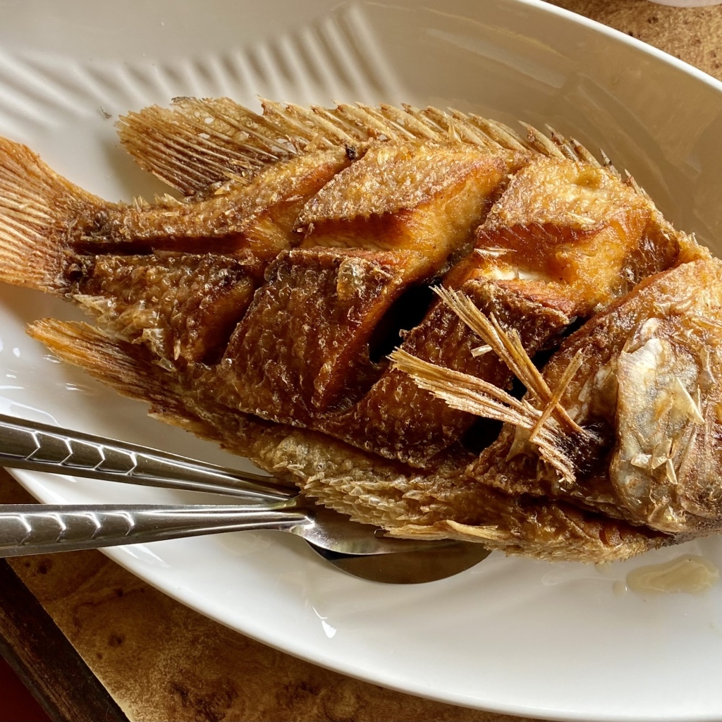 Запеченный карп на белой тарелке