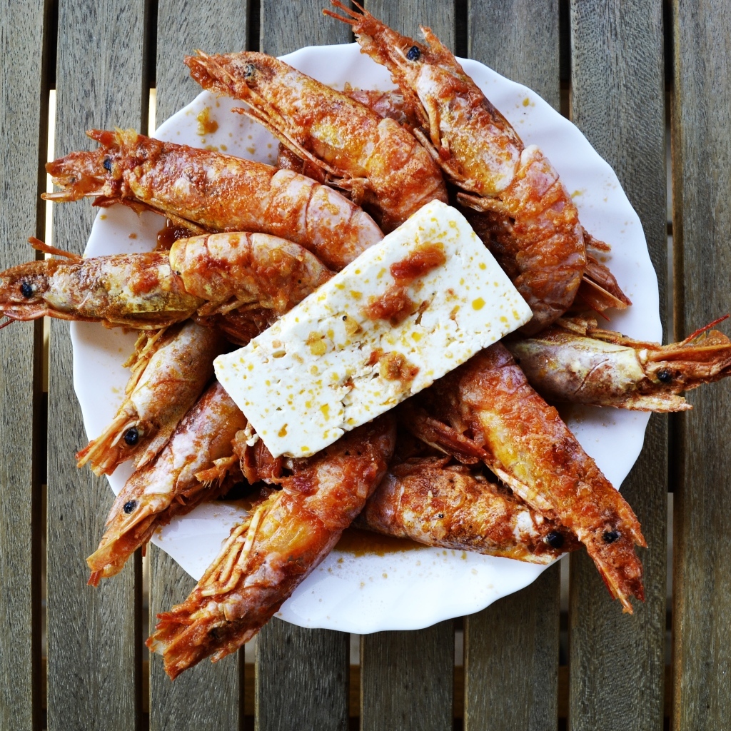 Жареные креветки на тарелке с сыром