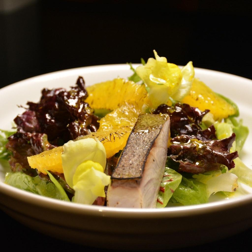 Кусочки рыбы с салатом и лимоном в тарелке