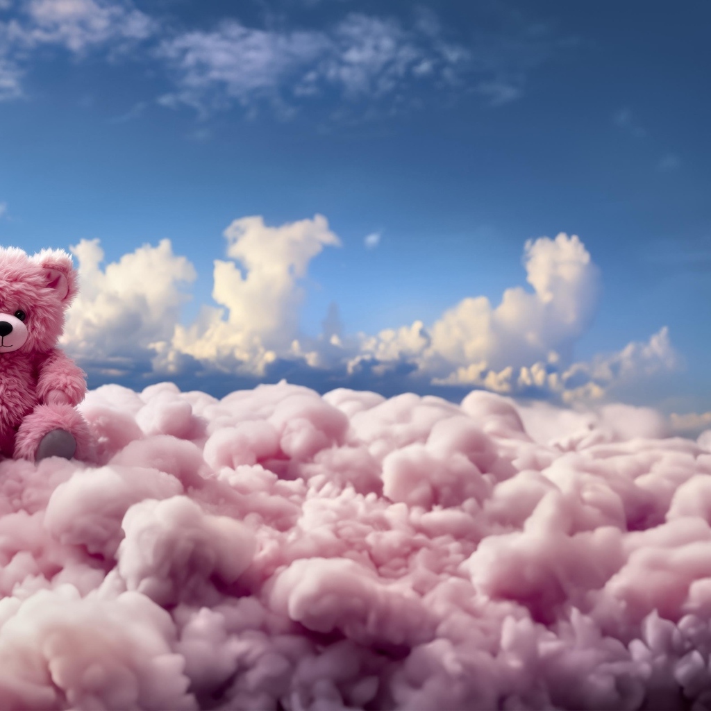 Розовый плюшевый медведь сидит на облаке