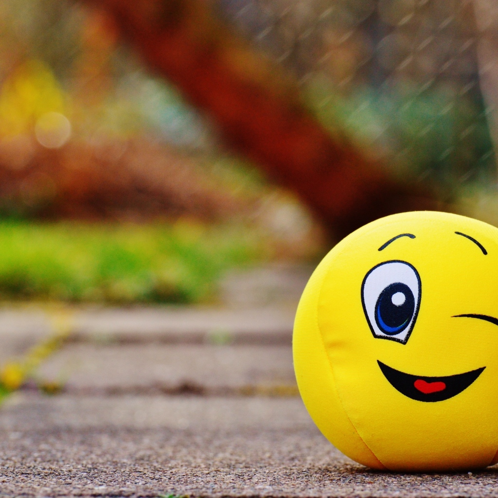 Желтый мягкий мяч смайл на дороге