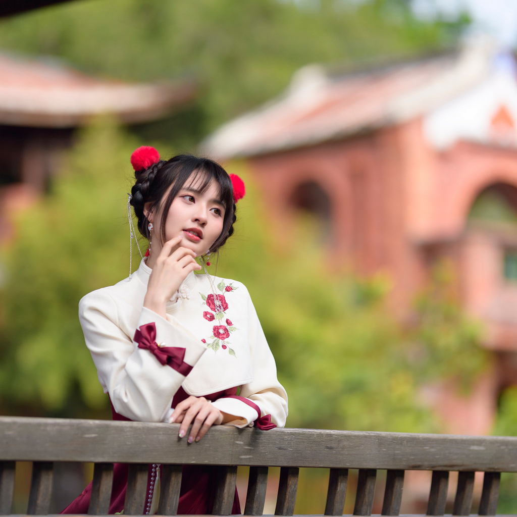 Девушка азиатка в народном костюме стоит у перил