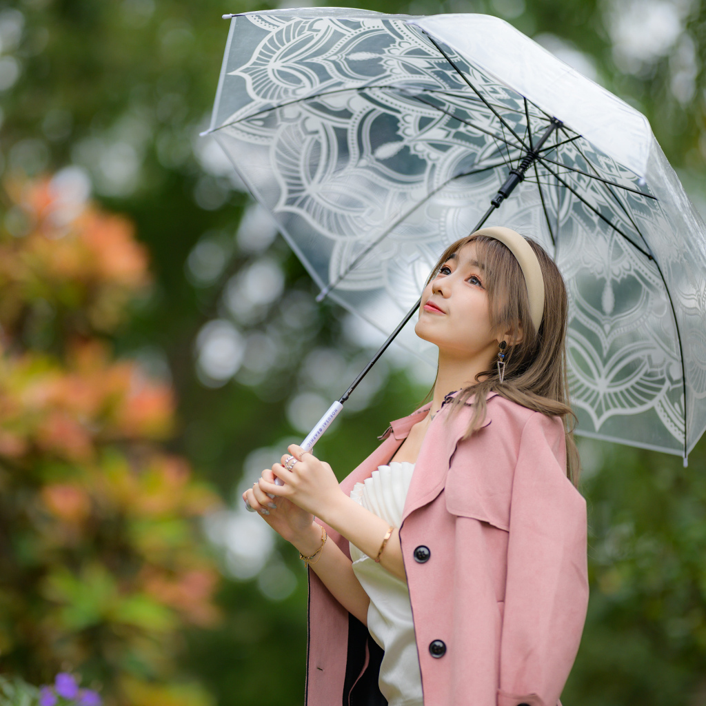 Девушка азиатка в пальто под прозрачным зонтом