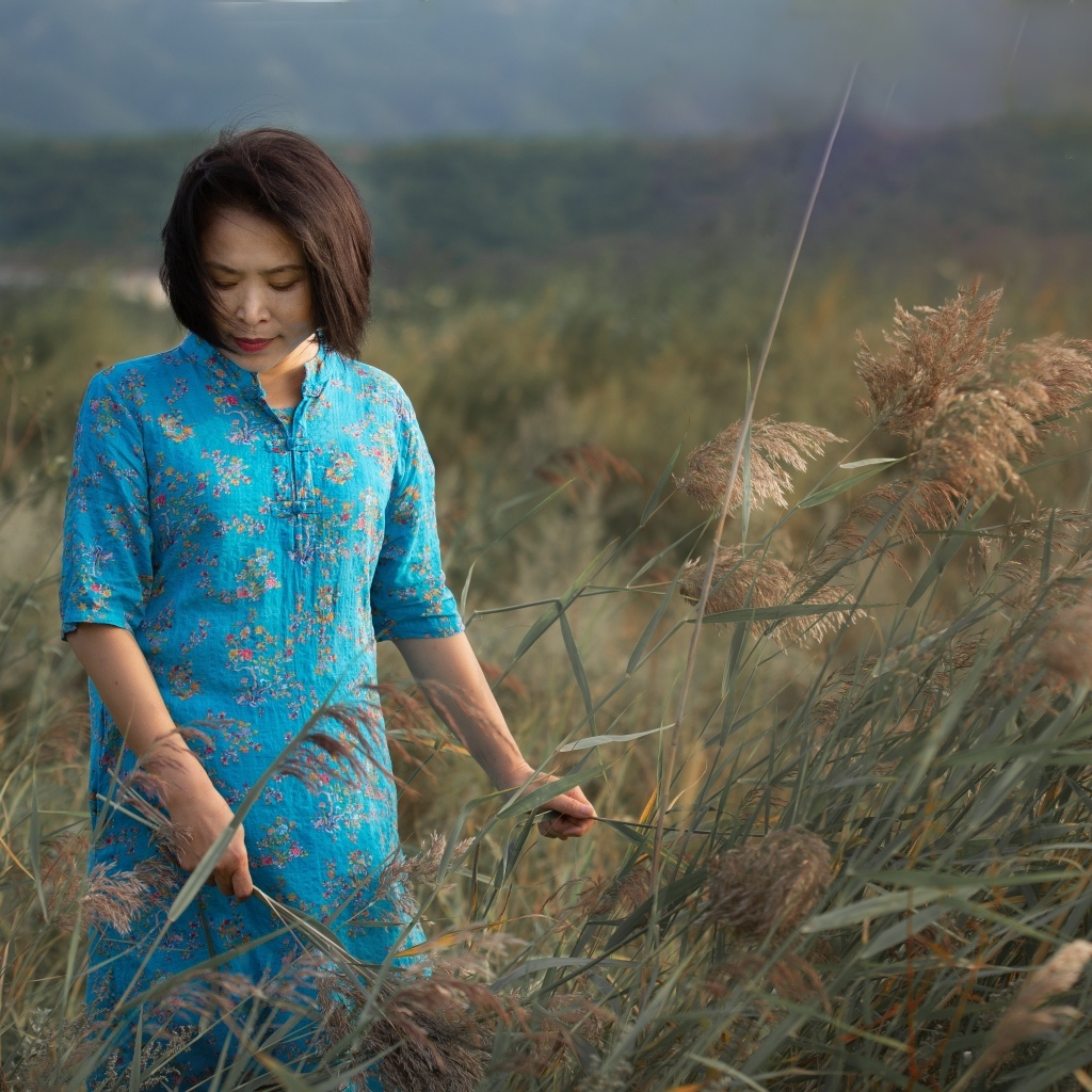 Девушка азиатка в платье на поле с колосьями