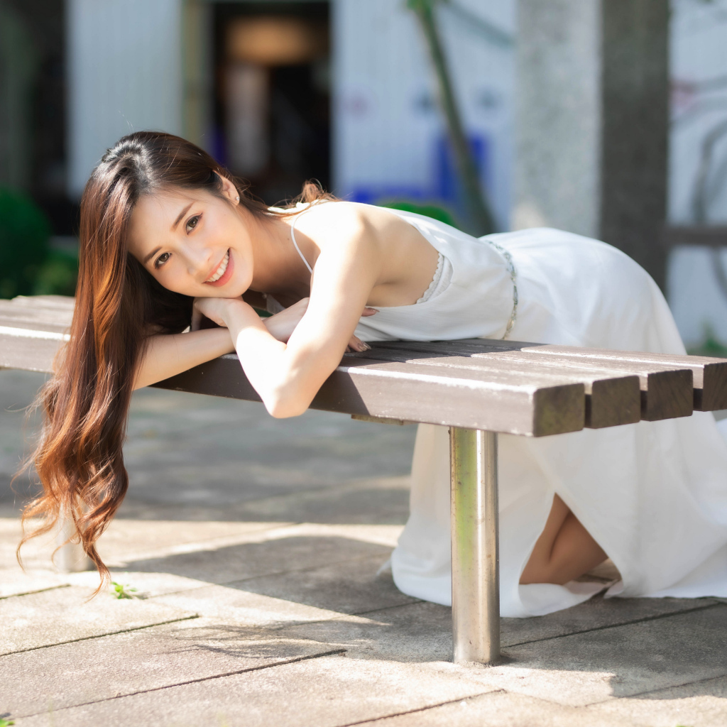 Девушка азиатка в белом платье с милой улыбкой