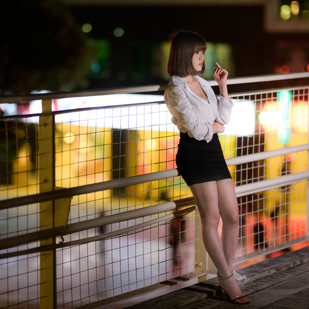 Азиатка в короткой черной юбке позирует для фото