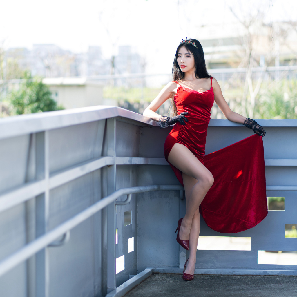 Азиатка в красном платье с короной на голове
