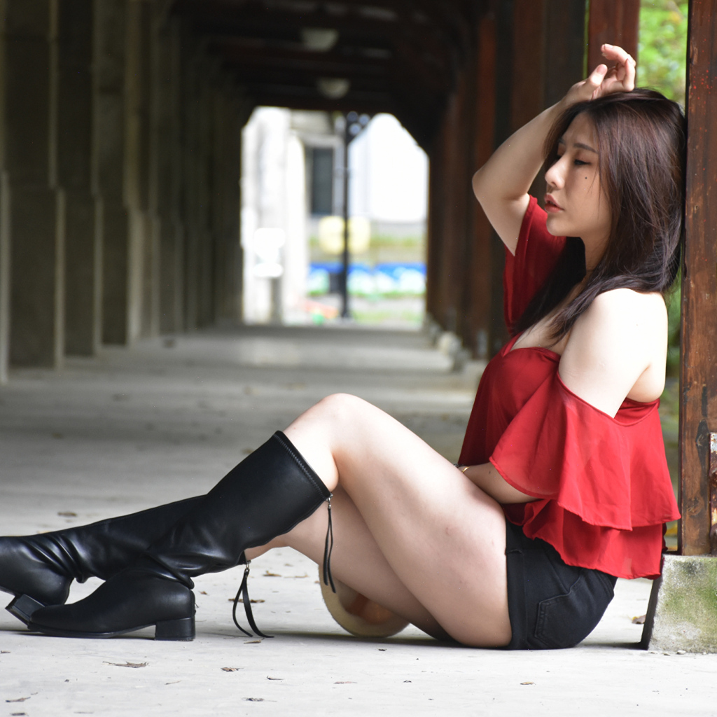 Азиатка с закрытыми глазами в черных сапогах