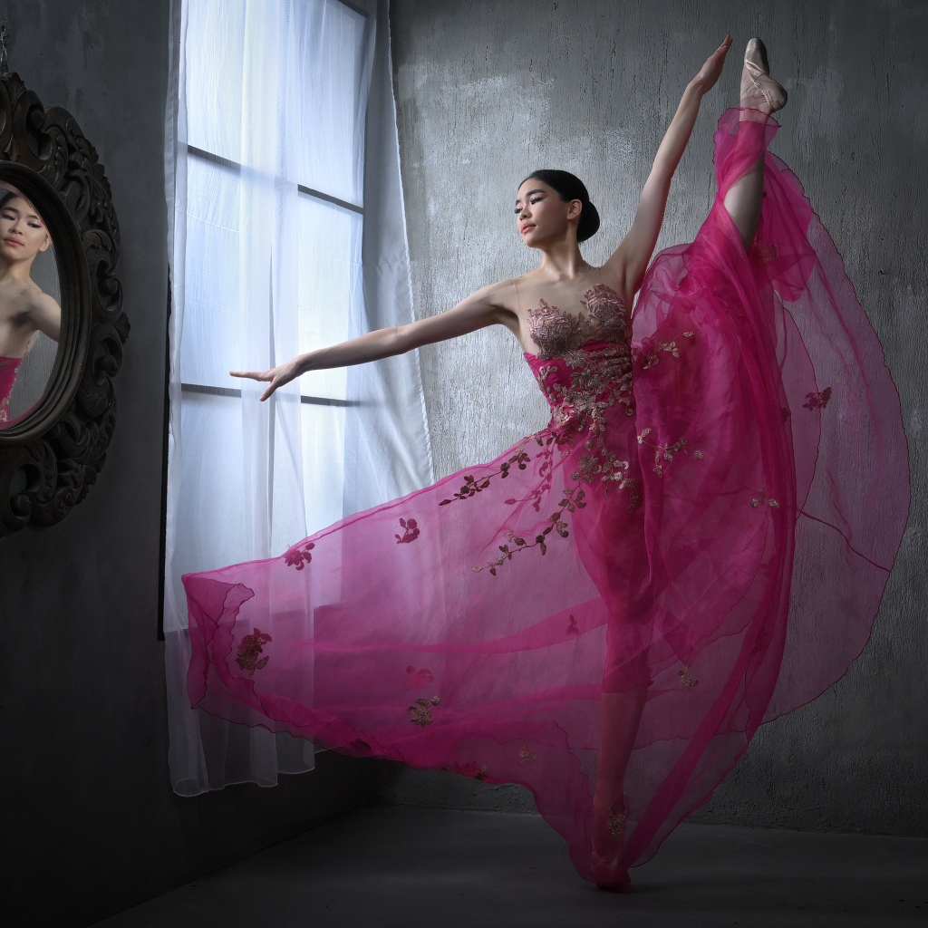 Девушка балерина в красивом розовом платье у окна