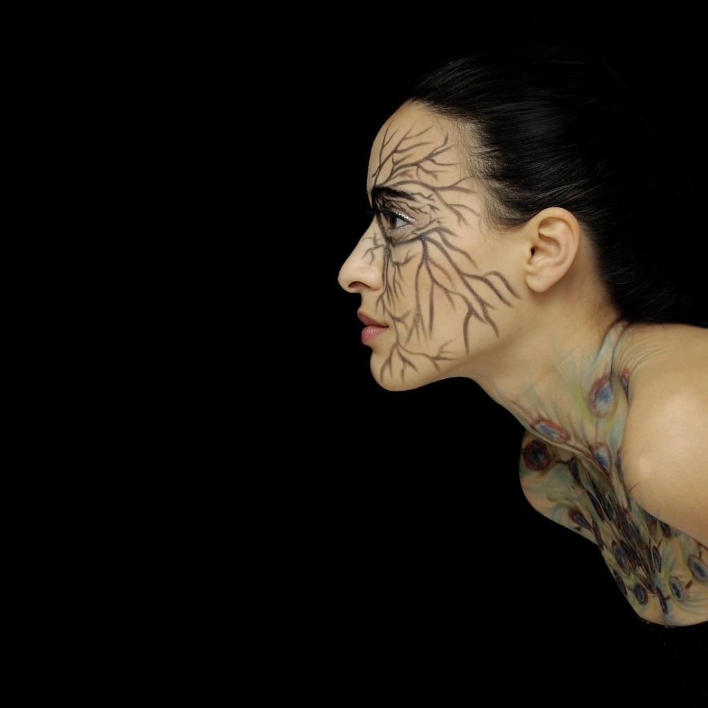 Красивая девушка с рисунком на теле на черном фоне