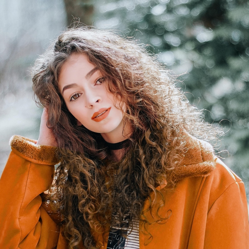 Красивая девушка с кудрявыми волосами и карими глазами