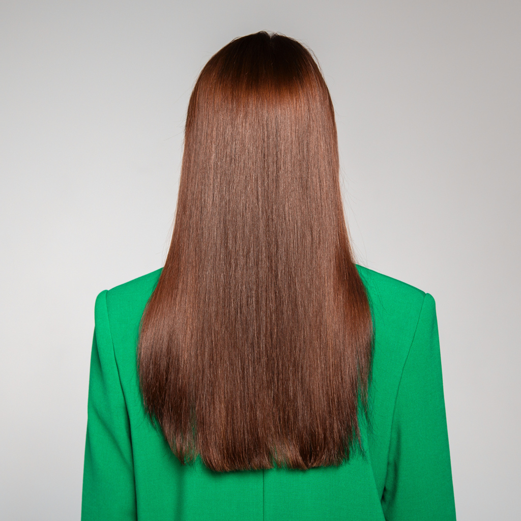 Красивые волосы девушки в зеленом пиджаке