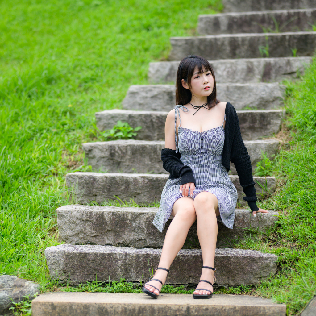 Красивая молодая девушка азиатка сидит на ступеньках