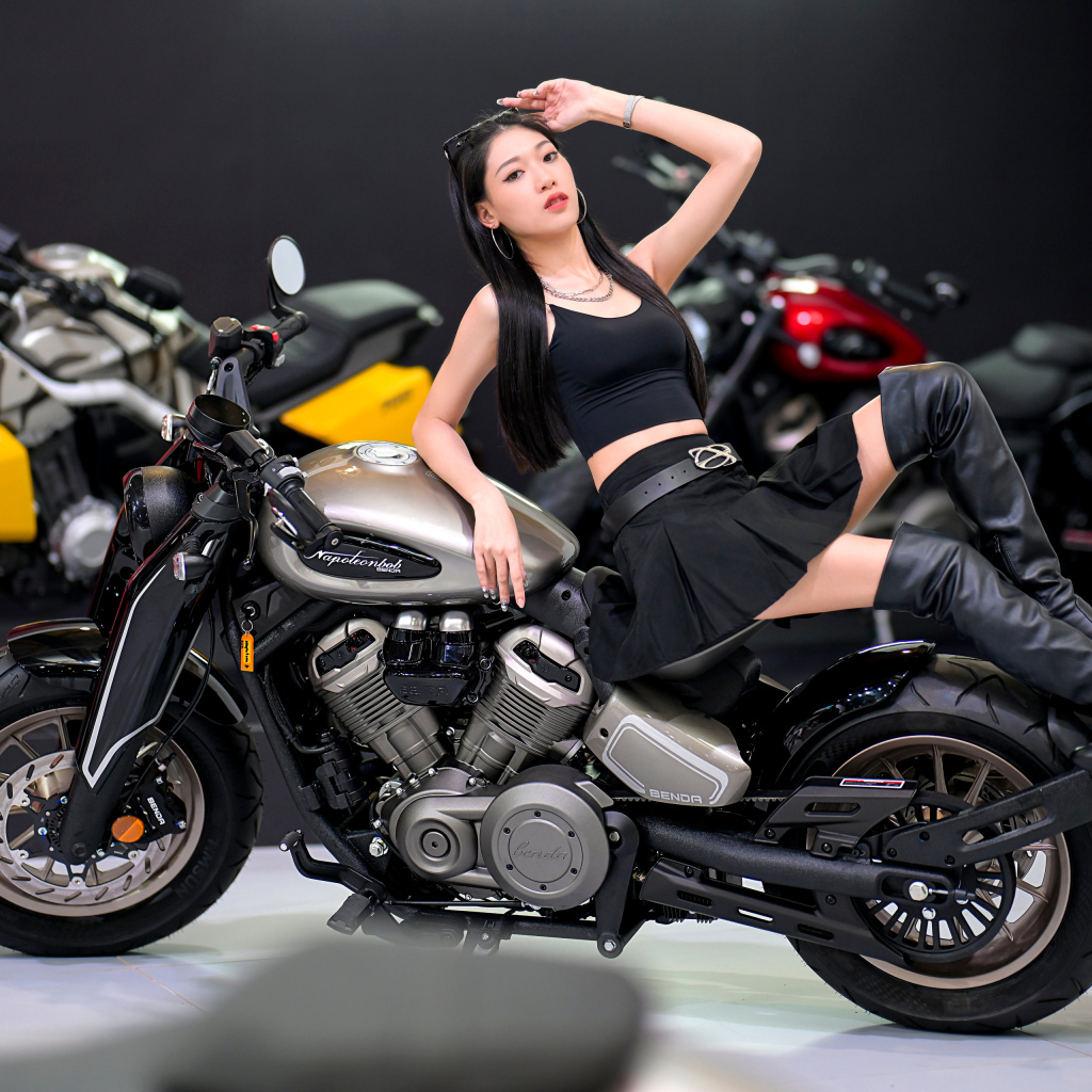 Брюнетка азиатка лежит на мотоцикле