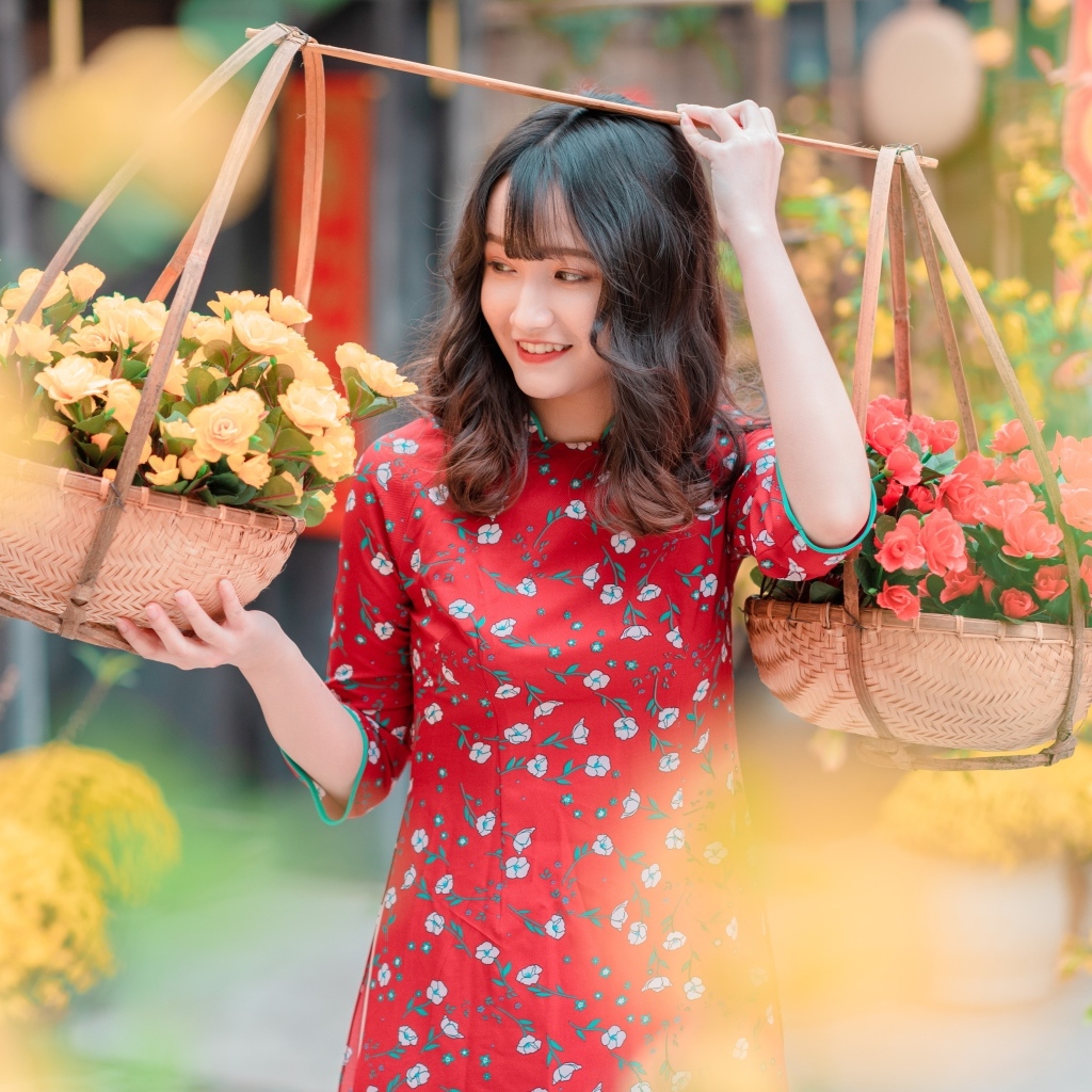 Милая девушка азиатка с цветами в красном платье
