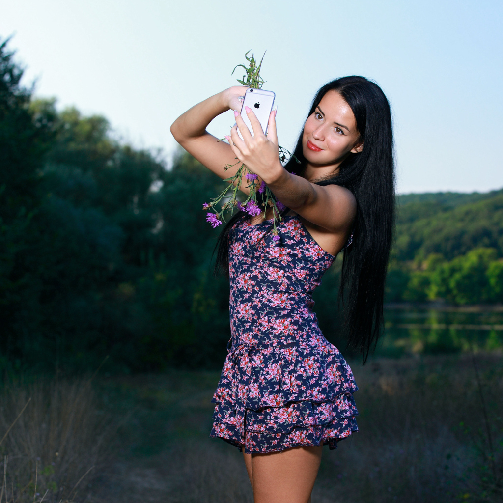 Милая брюнетка в коротком платье делает фото