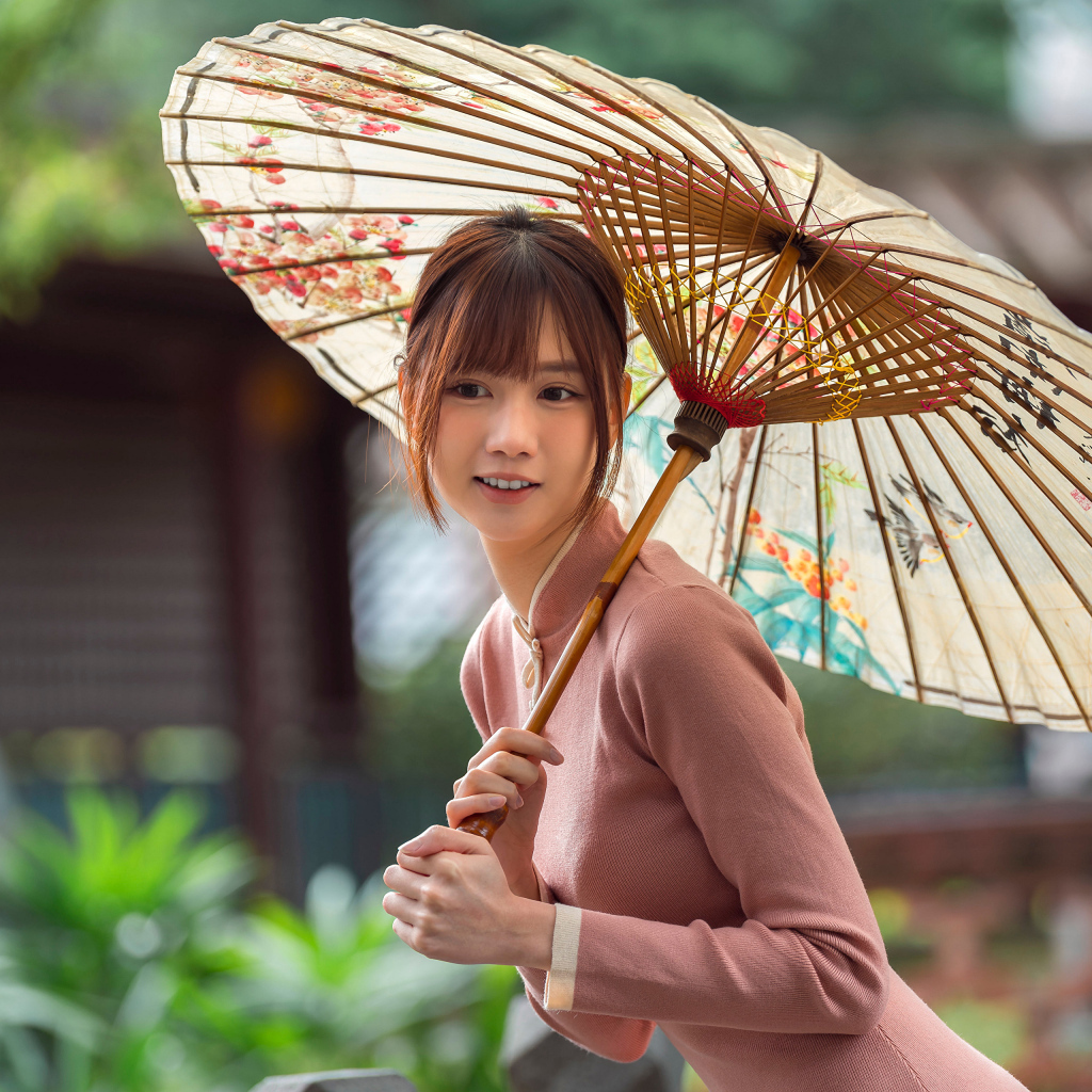 Милая улыбающаяся азиатка с зонтом