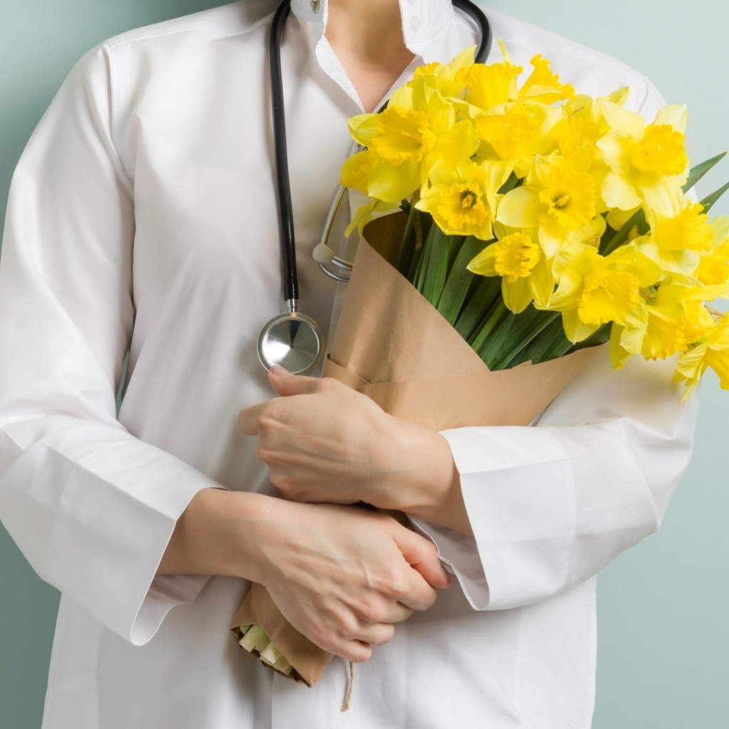 Доктор в букетом нарциссов  в руках