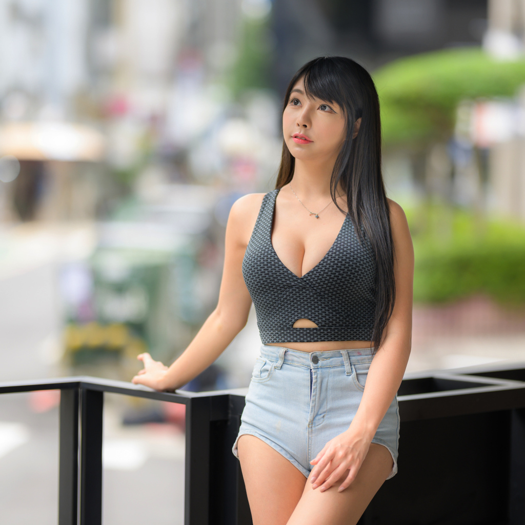 Мечтательная девушка азиатка в коротких шортах