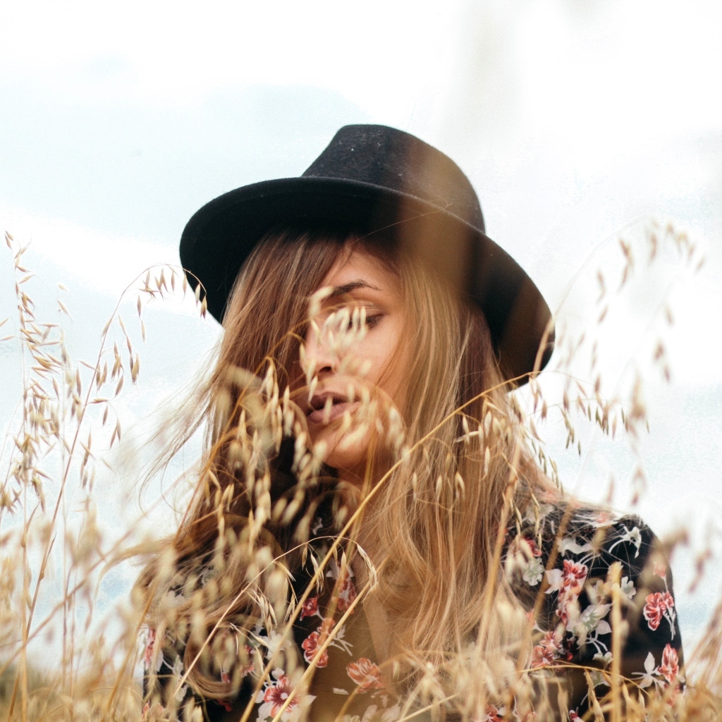 Девушка в черной шляпе в траве