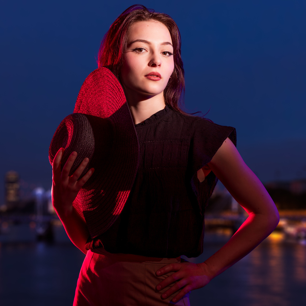 Девушка в лучах света со шляпой в руках