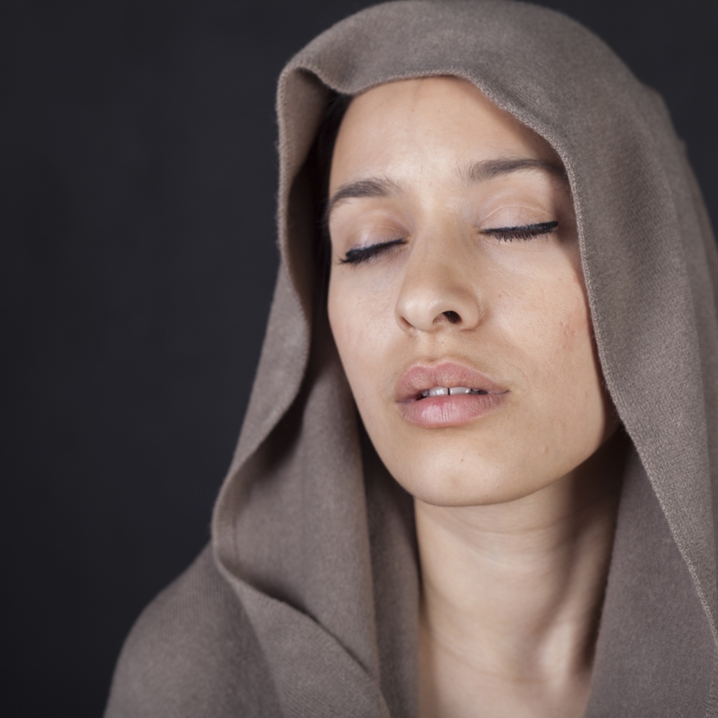 Девушка с закрытыми глазами с покрытой головой