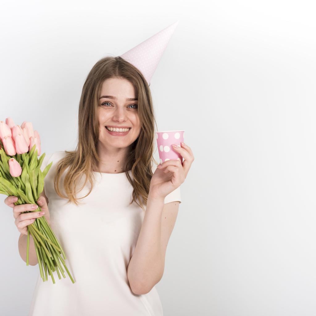 Счастливая девушка с букетом тюльпанов и подарком на день рождения