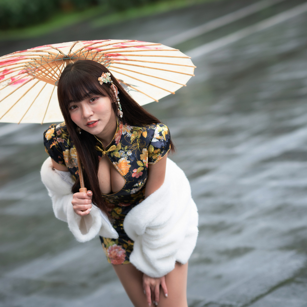 Настоящая азиатка стоит под зонтом