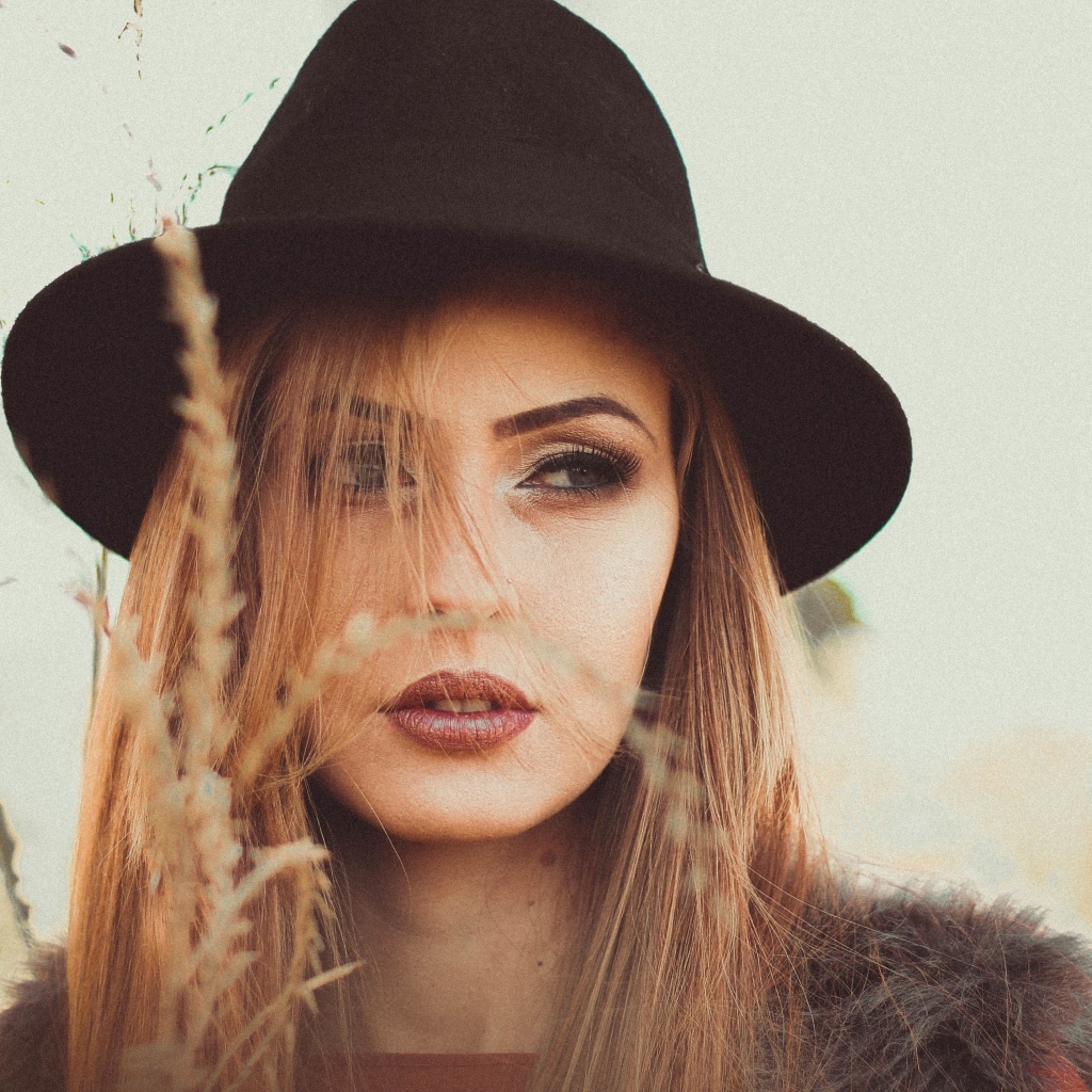 Серьезная девушка в черной шляпе 