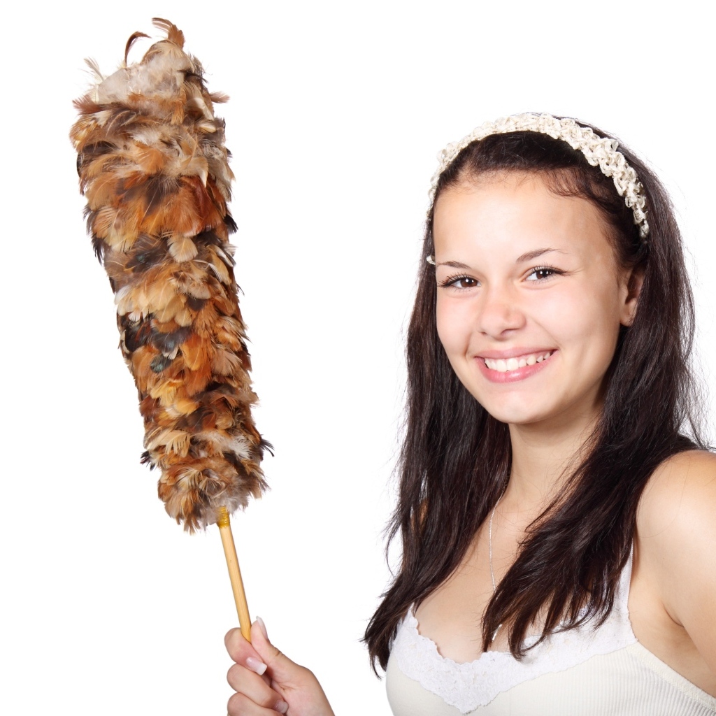 Улыбающаяся девушка убирается в комнате