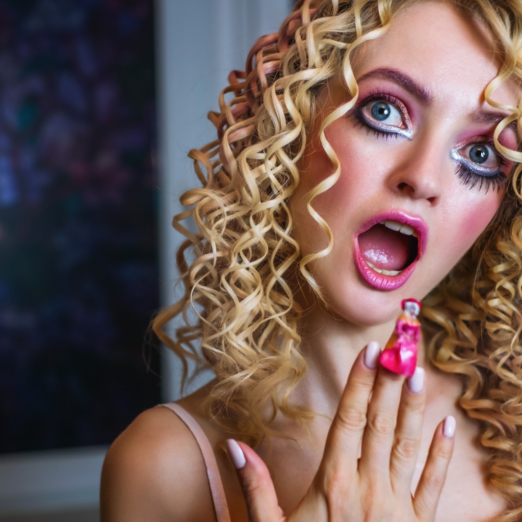Удивленная девушка блондинка с макияжем куклы