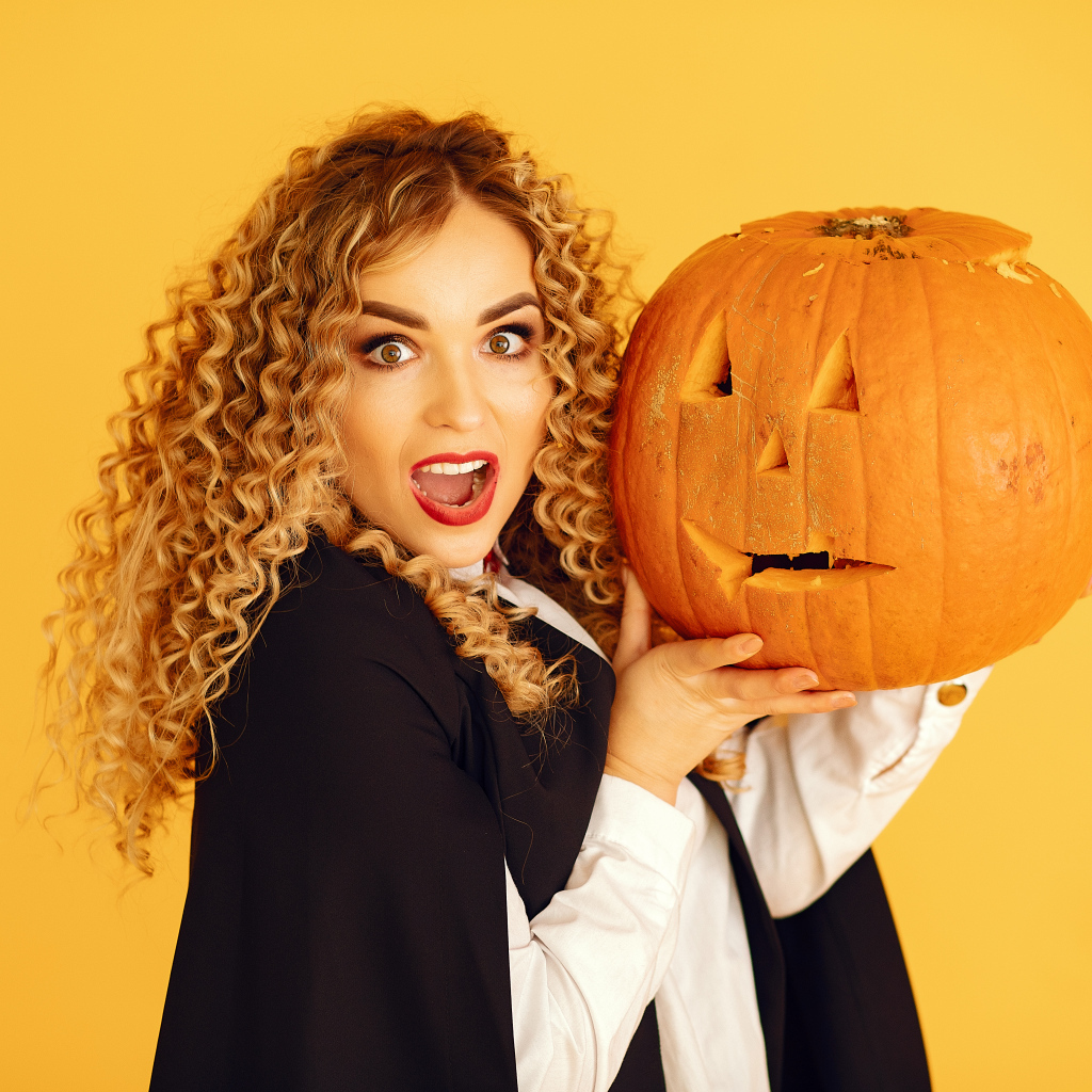 Удивленная девушка с тыквой на Хэллоуин