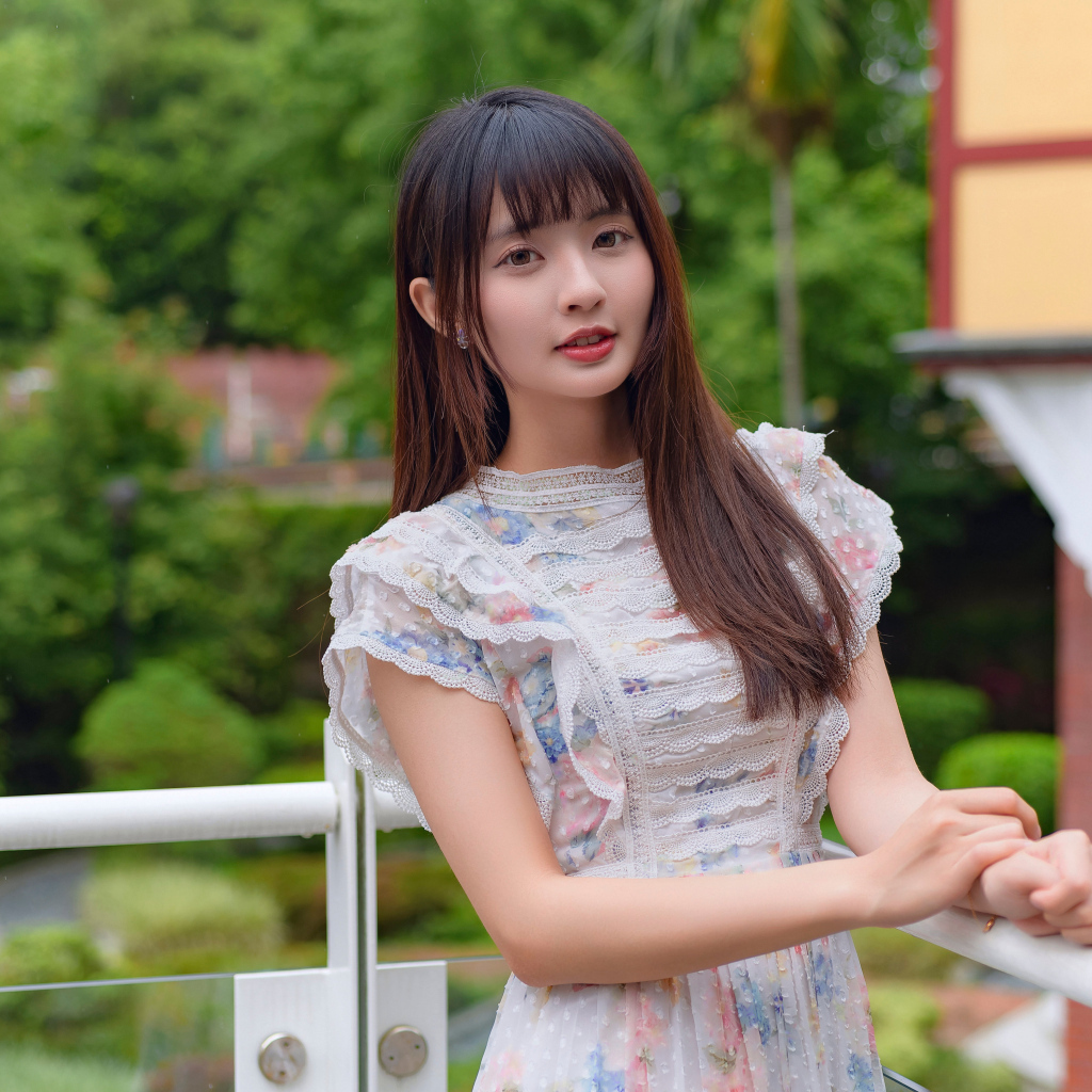 Нежный взгляд молодой длинноволосой азиатки в платье