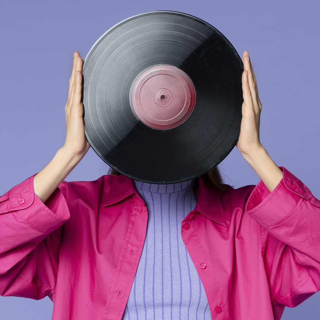 Девушка закрыла лицо пластинкой 