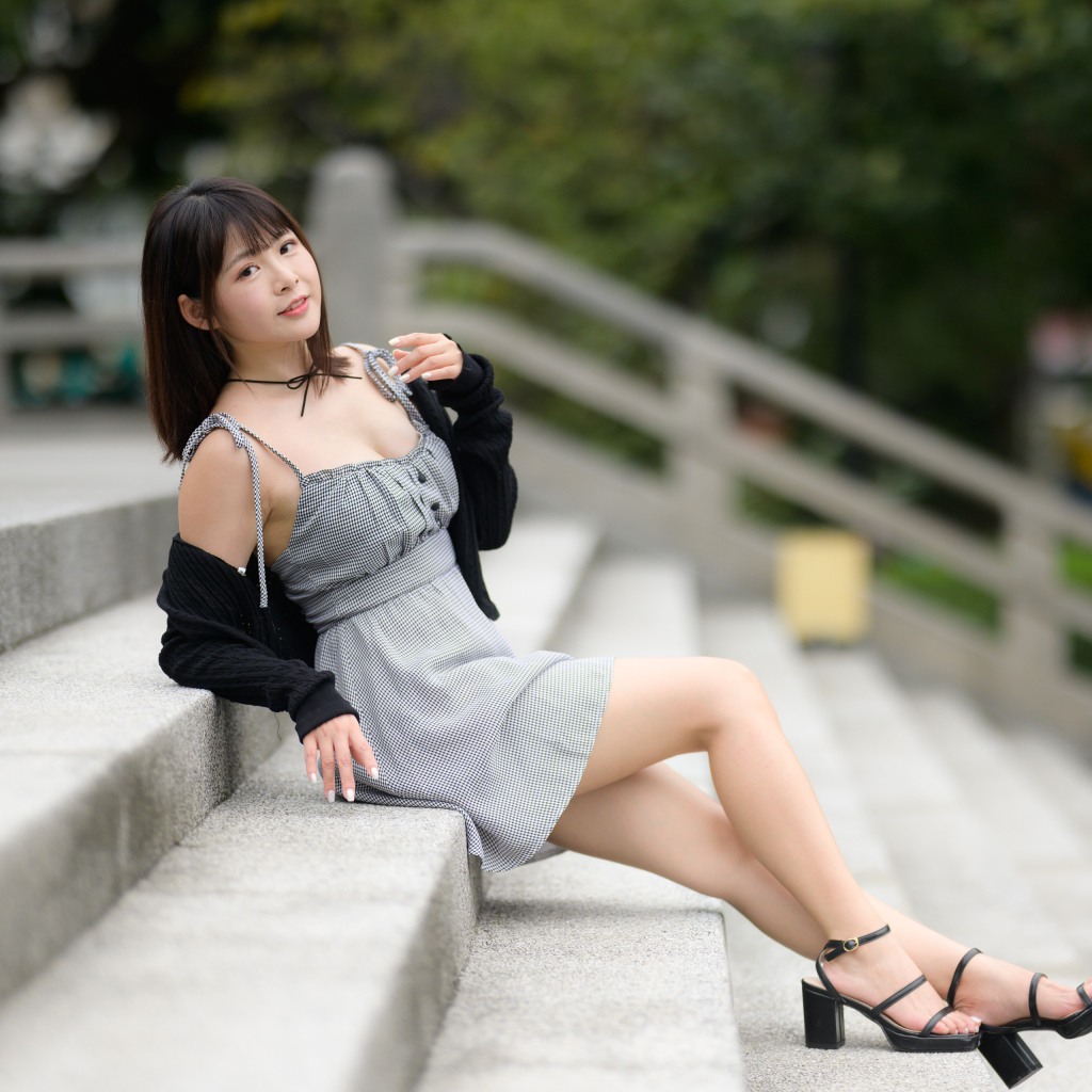 Молодая азиатка в платье лежит на ступеньках