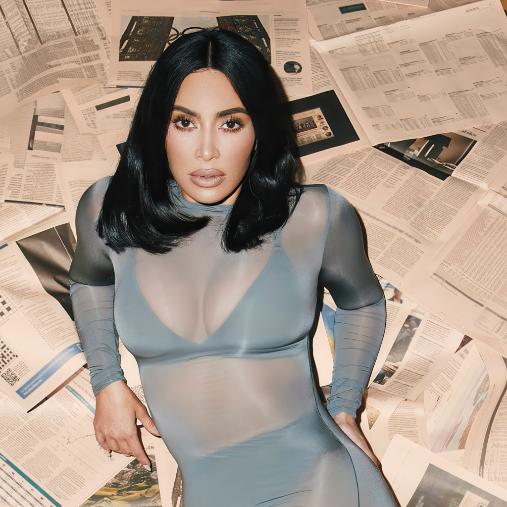 Модель Ким Кардашьян лежит на полу на газетах