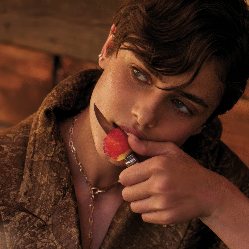 Модель Тейлор Хилл с ножом ест яблоко