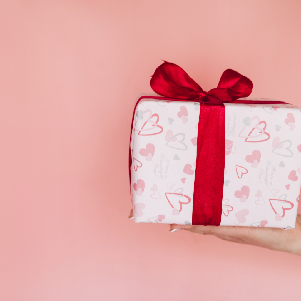 Девушка держит коробку с подарком