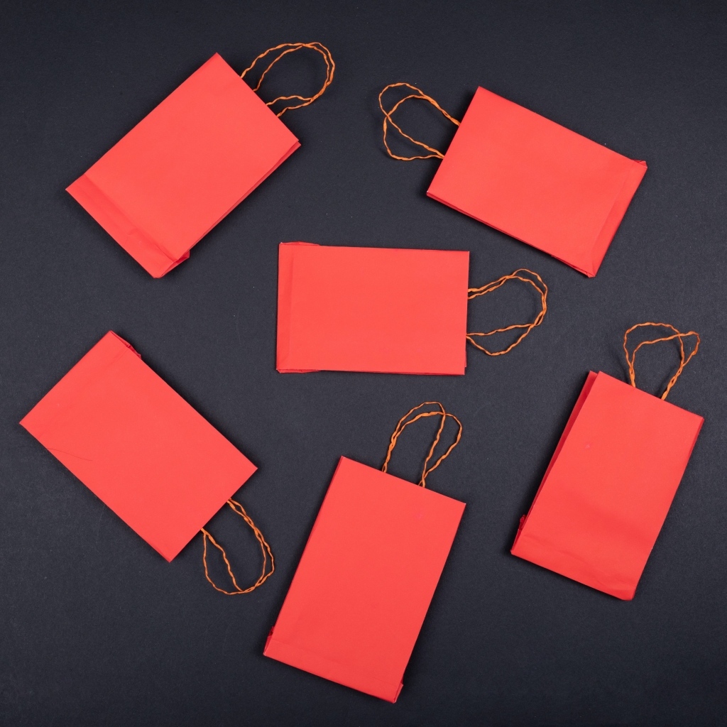Красные пакетики для подарков на черном столе
