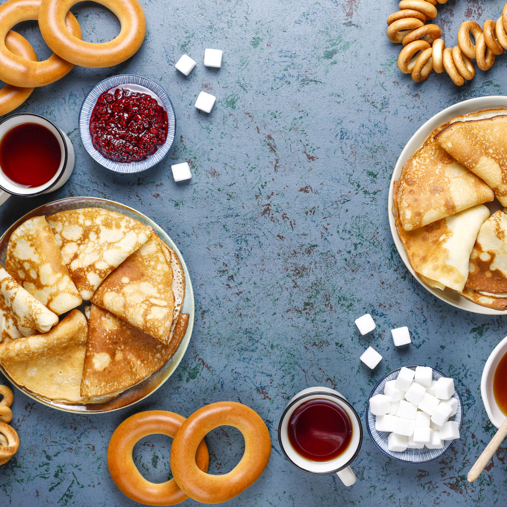 Тонкие блинчики, бублики и джем на столе на Масленицу