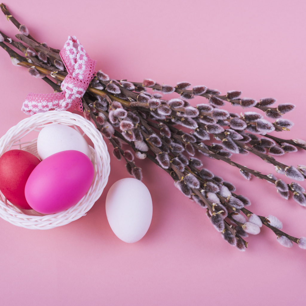 Ветки вербы с яйцами на розовом фоне