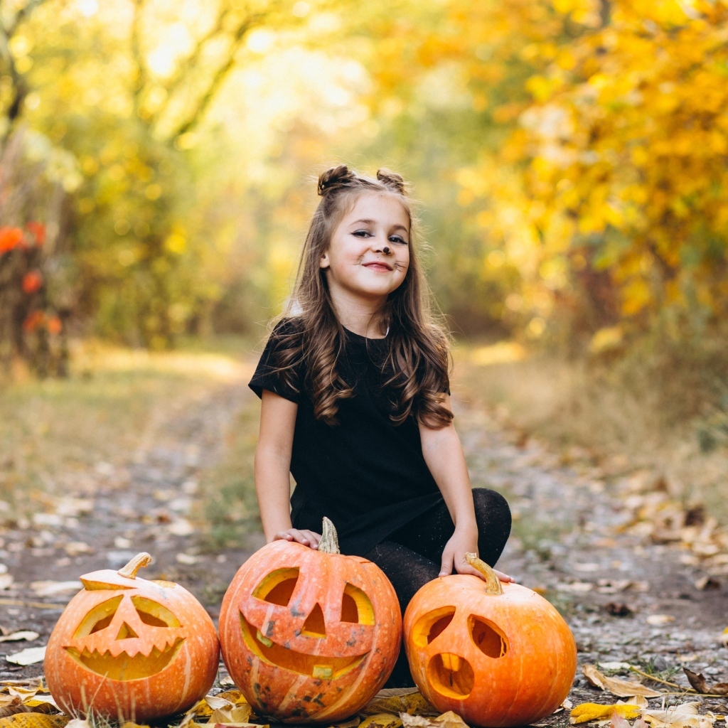 Девочка с тыквой в парке на праздник Хэллоуин