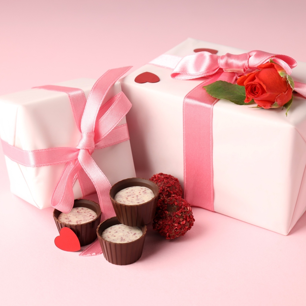 Два подарка с конфетами на розовом фоне на День Святого Валентина