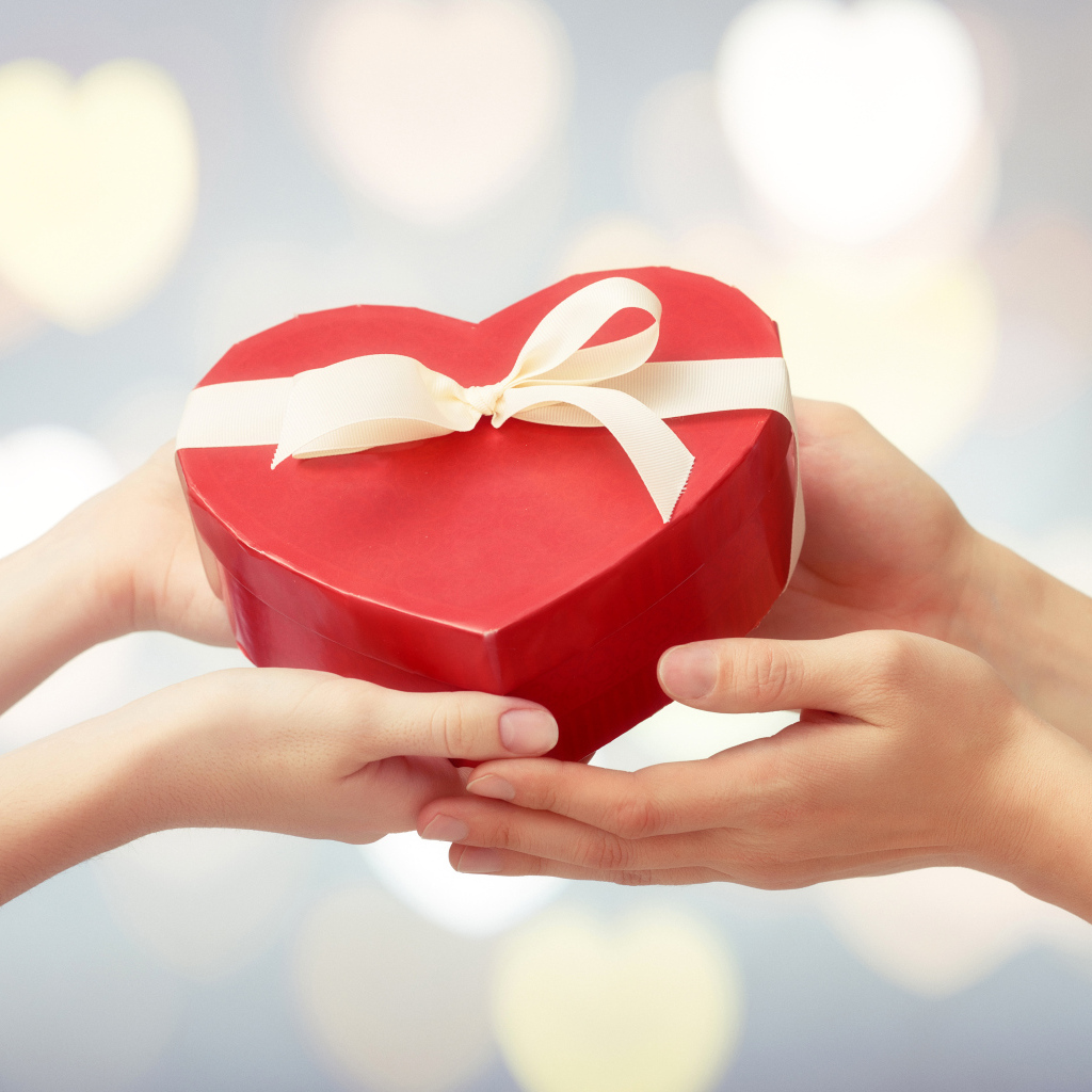 Коробка в форме сердца в руках у пары